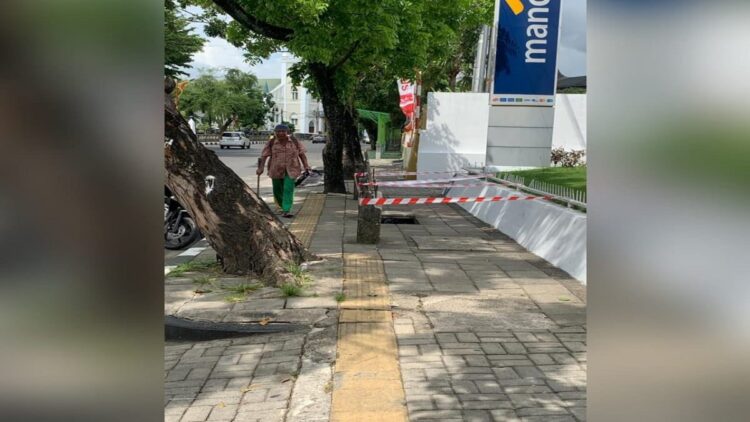 Seorang pejalan kaki lanjut usia (lansia) melintasi trotoar yang berlubang di Jalan Gereja, Kecamatan Padang Barat, Kota Padang. (Foto: Dok. Muhammad Aidil)
