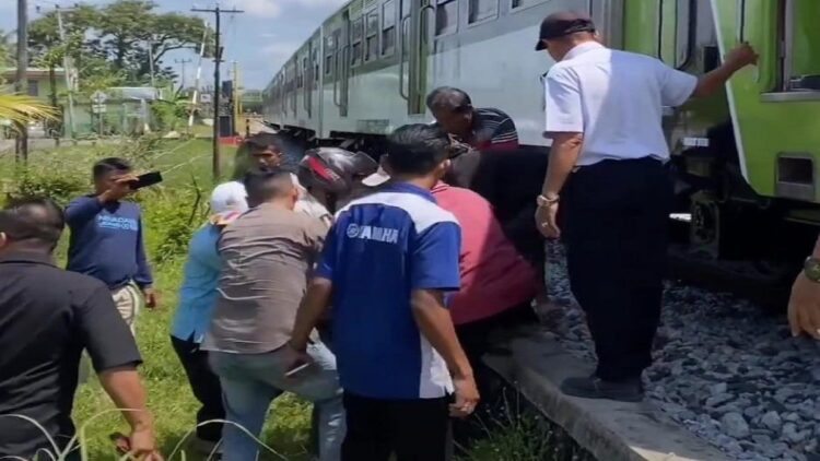 Diduga Melamun saat Menyeberang Rel, Remaja di Padang Tertabrak Kereta Api 1 Warga berupaya membantu menyelamatkan remaja yang tertabrak kereta api di Padang. (Foto: Dok. Istimewa)