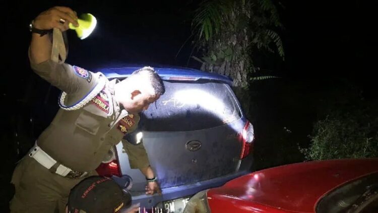 Satpol PP Damkar Agam Sita Belasan Botol Minol saat Operasi Rutin 1 Anggota Satpol PP Agam sedang menggeledah mobil yang membawa artis sawer di Puduang, Nagari Bawan, Kecamatan Ampeknagari, Kamis (9/3). (ANTARA/HO-Satpol PP Agam)