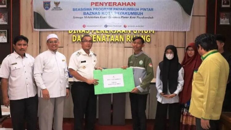Pj Wali Kota Payakumbuh Rida Ananda saat menyerahkan secara simbolis bantuan untuk mahasiswa dari Baznas setempat. (Antara/HO-Pemkot Payakumbuh)