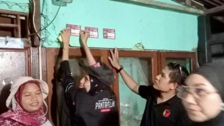 Koordinator Divisi Hukum Pencegahan Partisipasi dan Humas Bawaslu Pasaman Barat Aditia Pratama bersama tim saat menempelkan data pemilih Pemilu 2024 di rumah salah satu warga. (ANTARA/Altas Maulana)