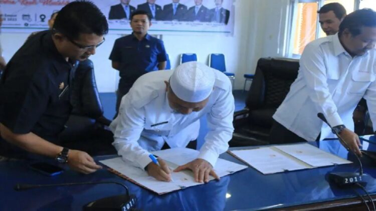 Bupati Pasaman Barat Hamsuardi saat menandatangani berita acara serah terima dan naskah hibah barang milik negara dari Kementerian Pekerjaan Umum dan Perumahan Rakyat (PUPR) melalui Balai Prasarana Permukiman Wilayah Sumatera Barat di Auditorium Kantor Bupati setempat, Kamis. (Foto: ANTARA)