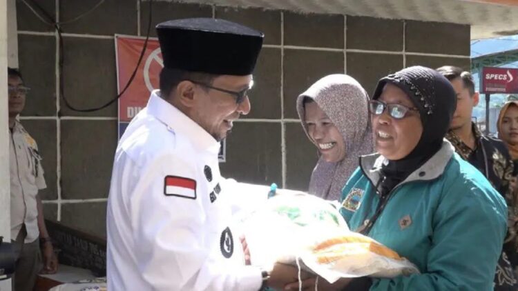 Bupati Tanahdatar Eka Putra secara simbolis salurkan bantuan cadangan pangan kepada salah seorang keluarga penerima manfaat ( KPM) Kamis, (13/4) (Antara/Etri Saputra).