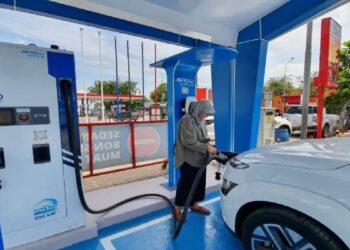 Seorang perempuan di SPKLU terlihat sedang mengisi daya energi mobil listrik. Otomotif Indonesia sudah mulai fokus pada moda yang satu ini. (dok. Antara)