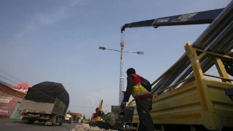 Pekerja menyelesaikan pemasangan lampu Penerangan Jalan Umum (PJU) di Jalur Pantura Losarang, Indramayu, Jawa Barat, Minggu (9/4/2023). Pemasangan lampu PJU di jalur pantura tersebut untuk meningkatkan kenyamanan para pemudik saat arus mudik mendatang. ANTARA FOTO/Dedhez Anggara/nz.