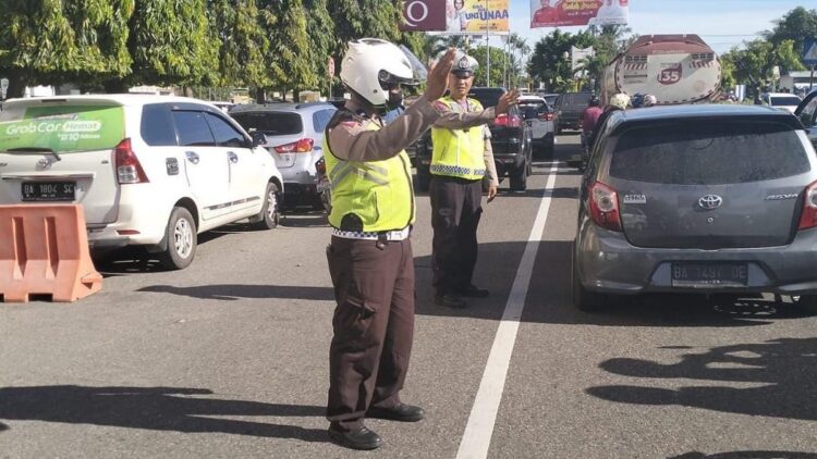 Kendaraan Parkir di Pinggir Jalan, Basko Grand Mall Macet Parah 1 Personel Satlantas Polresta Padang mengatur lalu lintas di depan Basko Grand Mall. (Dok. Radarsumbar.com)