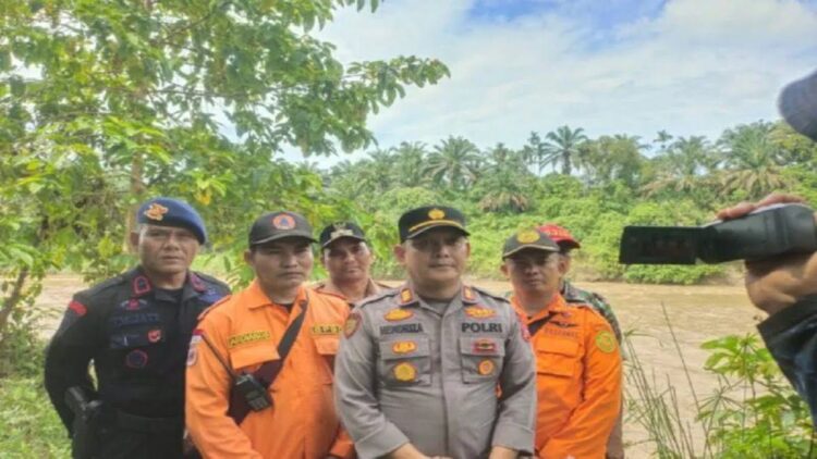 Bantu Pencarian Orang Hanyut di Sungai Batanghari, Polres Dharmasraya Kerahkan Perahu Karet 1 Kapolsek Koto Baru AKP Hendriza (tengah) bersama tim SAR gabungan saat memberi keterangan kepada awak media di lokasi korban dilaporkan hanyut, di Nagari Sungai Langkok, Kecamatan Tiumang, Kabupaten Dharmasraya, Selasa (9/5). (Antara/Ilka Jensen)