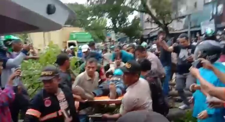 Tangkapan layar video driver ojol dievakuasi ke mobil ambulans usai ditimpa pohon tumbang. (Foto: Dok. Istimewa)