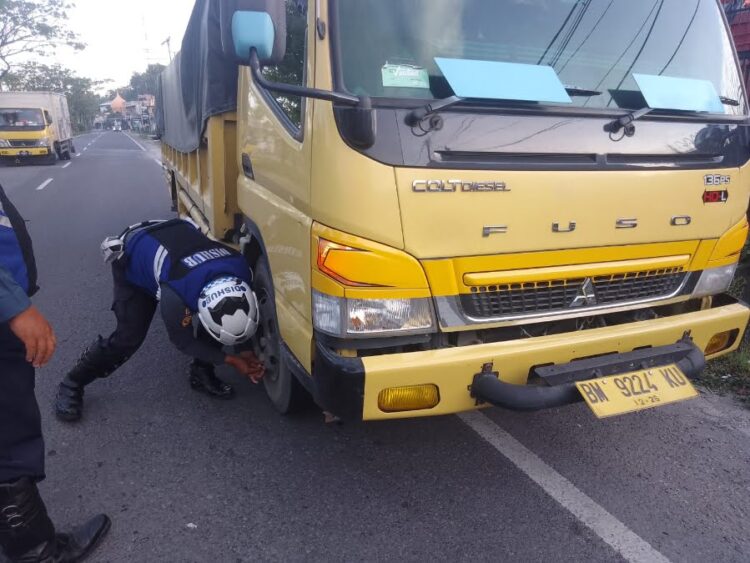 Polisi dan Dishub Padang Gembos Ban 4 Truk yang Parkir Sembarangan 1 Petugas gabungan mengempeskan ban truk yang parkir secara sembarangan. (Dok. Dishub Padang)
