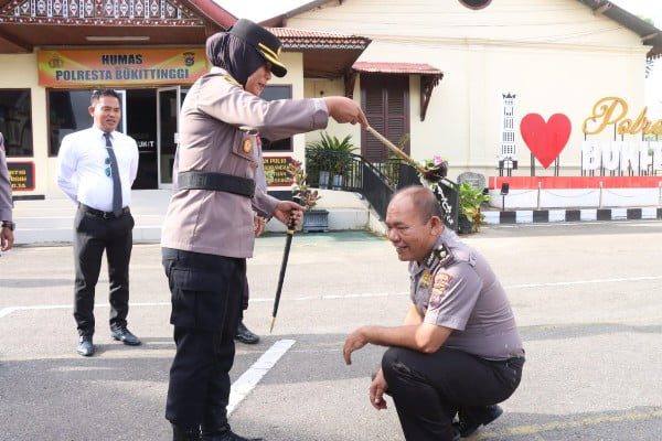 Kasi Humas Polresta Bukittinggi Naik Pangkat jadi Kompol, Padang Kapan? 1 Kapolresta Bukittinggi, Kombes Yessi Kurniati melakukan tradisi siraman kepada Kasi Humas Polresta Bukittinggi, Kompol Robinhot Sitinjak dalam upacara kenaikan pangkat. (Foto: Dok. Polresta Bukittinggi)