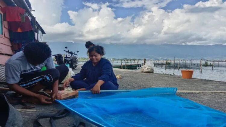 Nelayan Danau Maninjau sedang memperbaiki jaring yang diginakan untuk menangkap ikan. Dok Antara/Yusrizal