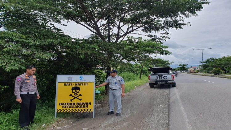 Terlihat Kanit Laka Lantas Polresta Padang Iptu Arisman memasang plang imbauan rawan lakalantas. (Foto: Dok. Istimewa)