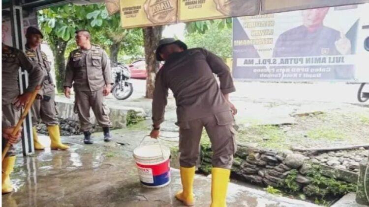 Satpol PP Padang membantu warga membersihkan rumah seusai banjir. (ANTARA/HO Diskominfo Padang)