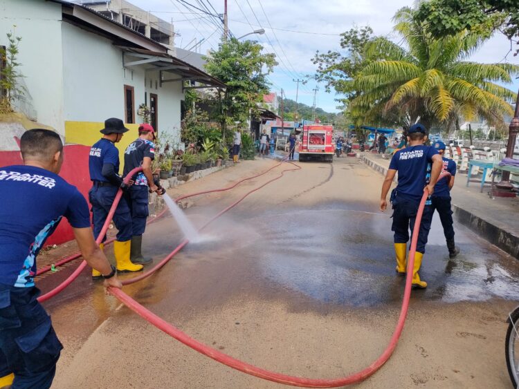 Petugas melakukan pembersihan fasilitas umum (fasum) menggunakan air pasca banjir yang terjadi beberapa waktu lalu. (Foto: Dok. Dinas Damkar Kota Padang)