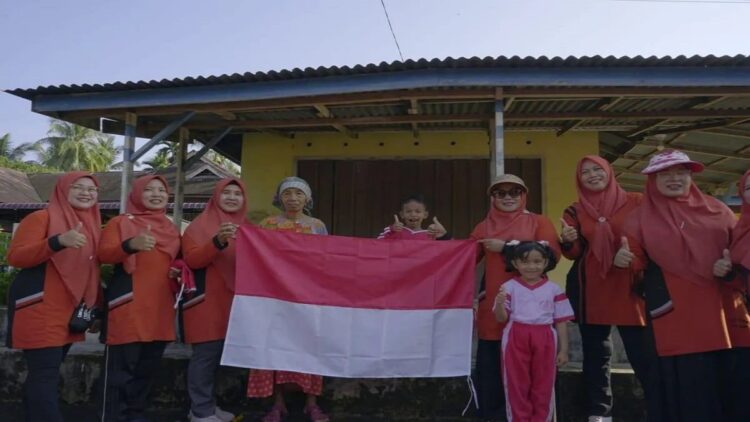 Ketua TP PKK Agam Ny Yenni Andri Warman membagikan bendera kepada warga, Rabu (9/8). Dok Diskominfo Agam
