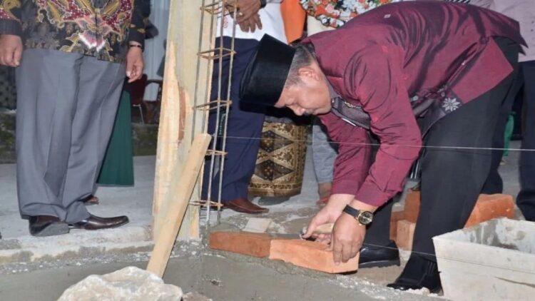 Bupati Agam Andri Warman sedang meletakkan batu pertama perbaikan RTLH di Canduang. Dok Diskominfo Agam