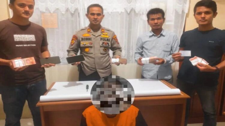Kapolsek Koto Parik Gadang Diateh IPTU Robbi Gunawan memperlihatkan barang bukti berupa uang beserta tersangka pelaku pencurian uang seorang guru. Antara/Erik