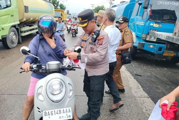 Kapolsek Lubukbegalung, Kompol Mochammad Rosidi membagikan bendera merah putih kepada pengendara. (Foto: Dok. Istimewa)
