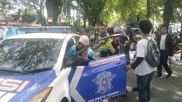 Polisi bantu anak pendemo Air Bangis yang step. (dok. Radarsumbar.com)