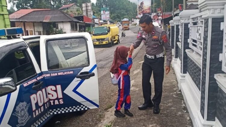 Salah seorang murid tengah bersalaman dengan petugas kepolisian, Satlantas Polres Solok saat memberikan pelayanan antar jemput murid ke sekolah (ANTARA/HO-Humas Polres Solok)