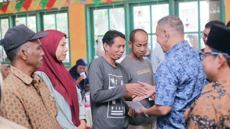 Bupati Pesisir Selatan Rusma Yul Anwar membagikan secara simbolis KIS PBI pada masyarakat Kecamatan Linggo Sari Baganti. (Foto: Dok. ANTARA)