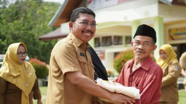 Asisten I Bidang Pemerintahan Setdakab Solok Selatan Efi Yandri menyerahkan bantuan pangan Nasional kepada masyarakat penerima manfaat di Kecamatan Sangir Batang Hari, Senin. Antara/Erik