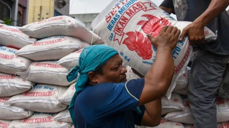 Pekerja memanggul karung berisi beras saat bongkar muat di Pasar Petisah, Medan, Sumatera Utara, Sabtu (9/9/2023). ANTARA FOTO/Fransisco Carolio/Spt. (ANTARA FOTO/FransiscoCarollio)