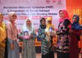 Ketua FKIK-SP Ny Fery Sarvino menyerahkan bantuan PMT dari FKIK-SP untuk Baduta Stunting dan Ibu Hamil di Nagari Labuah Panjang, Kecamatan X Koto, Kabupaten Solok, kepada Asisten Bidang Pemerintahan dan SDM Kabupaten Solok Muliadi Marcos. (dok. Humas)