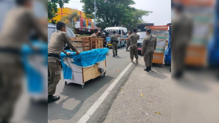 Satpol PP Padang mengangkut lapak PKL yang berjualan di badan jalan dan trotoar. (Foto: Dok. Satpol PP Padang)