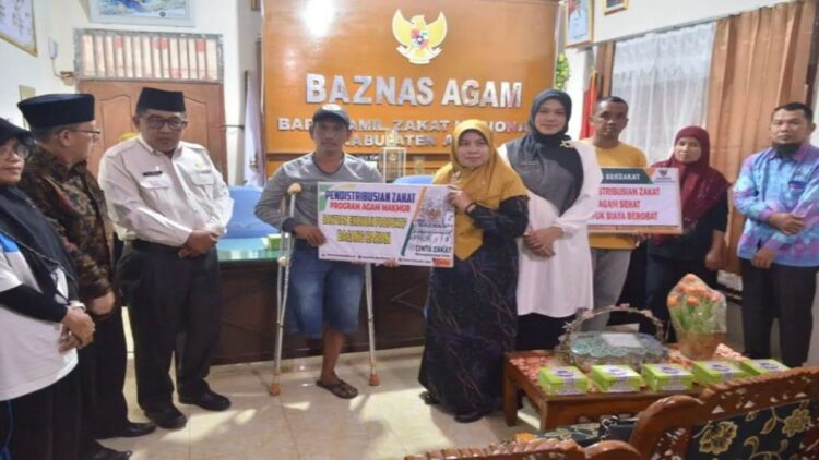 Ketua Baznas Agam Isman Imran menyerahan zakat bagi mustahik. Dok Humas Agam