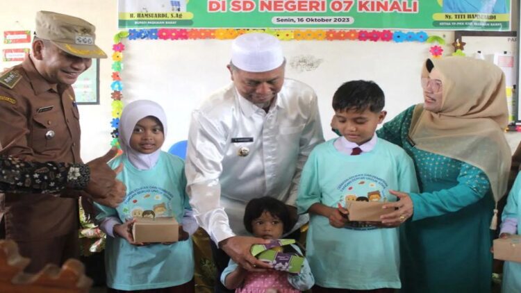 Bupati Pasaman Barat Hamsuardi (peci putih) saat memberikan kudapan bergizi ke siswa anak SD di Kecamatan Kinali, Selasa (17/10/2023). Antara/Altas Maulana.