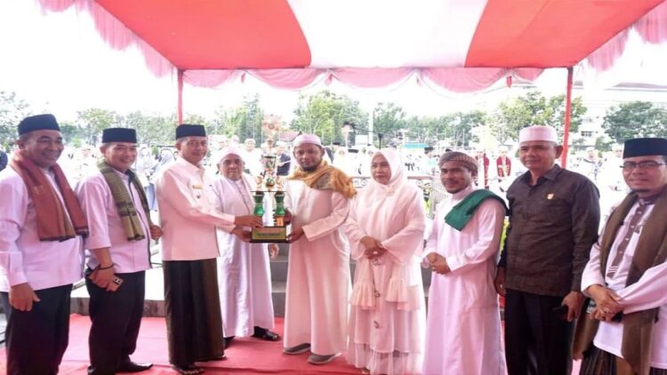 Wakil Bupati Pasaman Barat Risnawanto saat menyerahkan piala ke salah seorang santri usai peringatan Hari Santri Nasional di Simpang Empat, Minggu (22/10/2023). Antara/Altas Maulana.