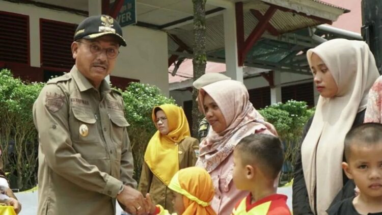 Bupati Solok Selatan Khairunas menyerahkan seragam bantuan Pemerintah Daerah kepada pelajar Taman Kanak-kanak. Antara/Er