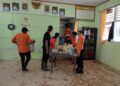 Petugas BPBD Kabupaten Limapuluh Kota membersihkan sisa material lumpur yang masuk ke dalam sekolah pasca banjir pada Selasa (24/10/2023) malam. (Foto: Dok. Pusdalops PB)