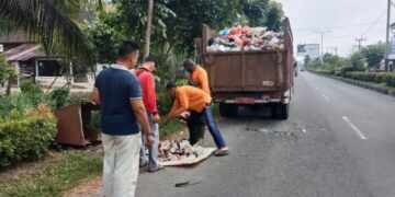 Petugas DLH Agam sedang membersihkan sampah. (dok. Antara)