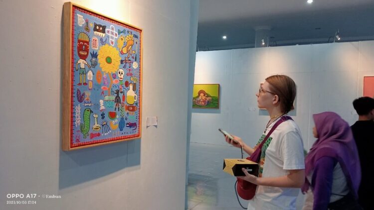 Wah! Ada 31 Lukisan Perupa Sumbar Dipamerkan di Pekan Kebudayaan Daerah 2023 1 seorang bule serius melihat pameran lukisan di PKD 2023