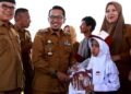 Bupati Tanah Datar, Eka Putra menyerahkan secara simbolis bantuan seragam sekolah pada jenjang pendidikan SD dan SMP pada Senin, (2/10/2023). (Foto: Dok. Antara/Etri Saputra)