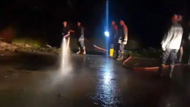 Petugas gabungan membersihkan material longsor yang menimbun dan memutus akses Jalan Nasional Sumbar-Riau, Rabu (15/11) malam. Pada Kamis (16/11) jalan sudah bisa kembali dilewati. (ANTARA/HO-BPBD 50 Kota)