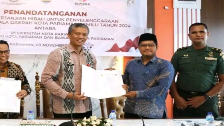 Ketua KPU Pariaman, Sumbar Ali Unan (kanan) berfoto bersama dengan Pj Wako Pariaman, Roberia saat penandatanganan Naskah Perjanjian Hibah Daerah (NPHD) bantuan keuangan untuk penyelenggaraan Pilkada 2024 . Antara/HO-Diskominfo Pariaman