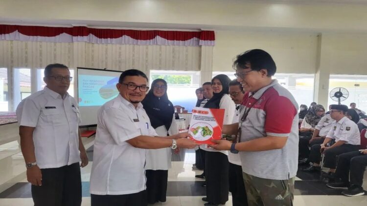 Asisten I Bidang Perekonomian dan Pembangunan Sekretaris Daerah Agam Jetson menyerahkan buku ke perwakilan OPD. Dok Diskominfo Agam