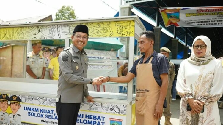 Bupati Solok Selatan Khairunas menyerahkan gerobak kepada salah seorang pedagang di lokasi Minggu. Antara/Erik
