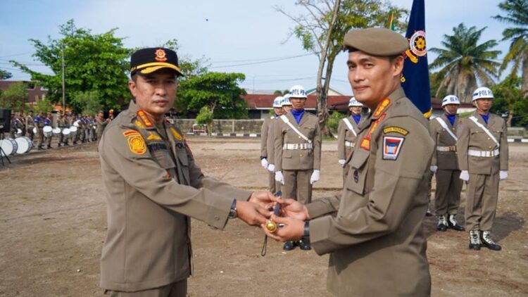 Diserahterimakan, Chandra Eka Putra Resmi Jabat Kepala Satpol PP Padang 1 Wakil Wali Kota (Wawako) Padang Ekos Albar (kiri) memberikan tongkat komando Satpol PP kepada Kepala yang baru, Chandra Eka Putra (kanan), Senin (27/11/2023) pagi. (Foto: Dok. Prokopim)