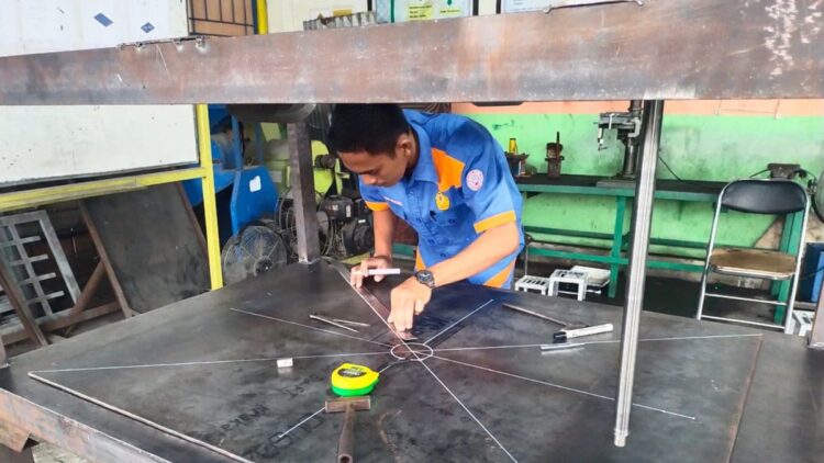SMK Semen Padang Produksi Mesin Press Restorasi untuk Arsip 1 Siswa SMK Semen Padang tengah mengerjakan pembuatan mesin press restorasi untuk Arsip di workshop SMK Semen Padang. (dok. Humas)