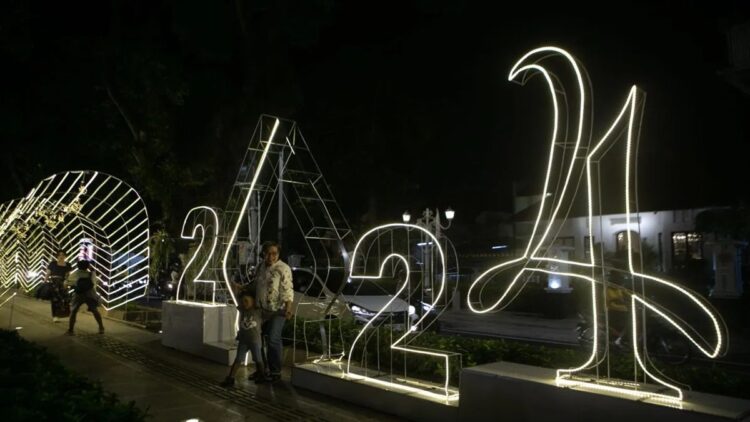Wisatawan berfoto di dekat hiasan lampu bertema tahun baru di kawasan Kotabaru, Yogyakarta, Selasa (26/12/2023). ANTARA FOTO/Hendra Nurdiyansyah/aww (Antara Foto/Hendra Nurdiyansyah)