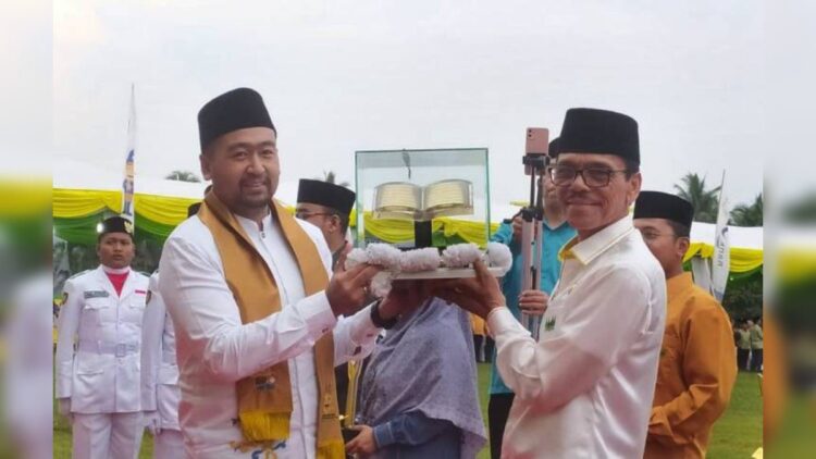 Wagub Sumbar menyerahkan piala kepada juara umum MTQ ke-40 Sumbar yang diterima Bupati Limapuluh Kota Safaruddin. (Foto: Dok. Kemenag Sumbar)