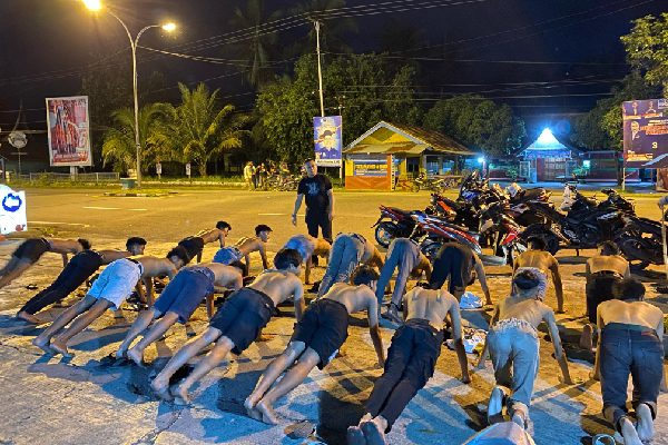18 Motor Diamankan di Pesisir Selatan, Polisi Beri Hukuman Ini ke Pemuda 1 Polisi memberikan hukuman push up kepada pemuda yang diduga melakukan aksi balap liar di Kabupaten Pesisir Selatan. (Foto: Dok. Polres Pessel)
