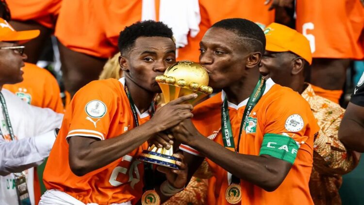 Pantai Gading Juara Piala Afrika usai Kalahkan Nigeri 2-1 1 Pemain Pantai Gading, Max-Alain Gradel dan Simon Adingra mencium trofi Piala Afrika 2023. (AFP/FRANCK FIFE)