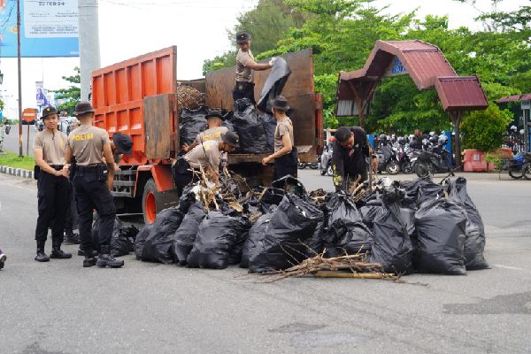 Sampah di Kota Padang Meningkat, DLH Tambah Armada dan Peralatan 1 Personel kepolisian membersihkan dan mengangkut sampah yang berserakan di Pantai Padang pada Selasa (6/2/2024) pagi. (Foto: Dok. Prokopim)