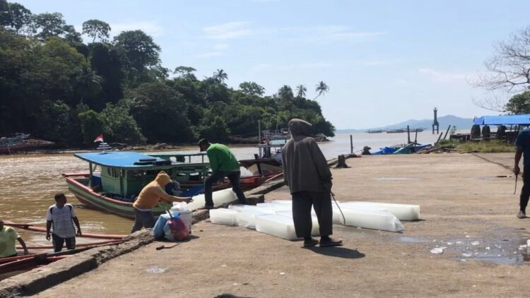 Sejumlah nelayan di Air Bangis Kecamatan Sungai Beremas Kabupaten Pasaman Barat saat menaikkan es balok ke kapal sebelum pergi melaut. (Antara/Altas Maulana).
