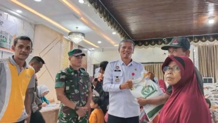 Penjabat Wali Kota Pariaman, Sumatera Barat Roberia (tengah) secara simbolis menyerahkan bantuan beras dari Bapanas kepada warga di daerah itu. Antara/HO-Diskominfo Pariaman